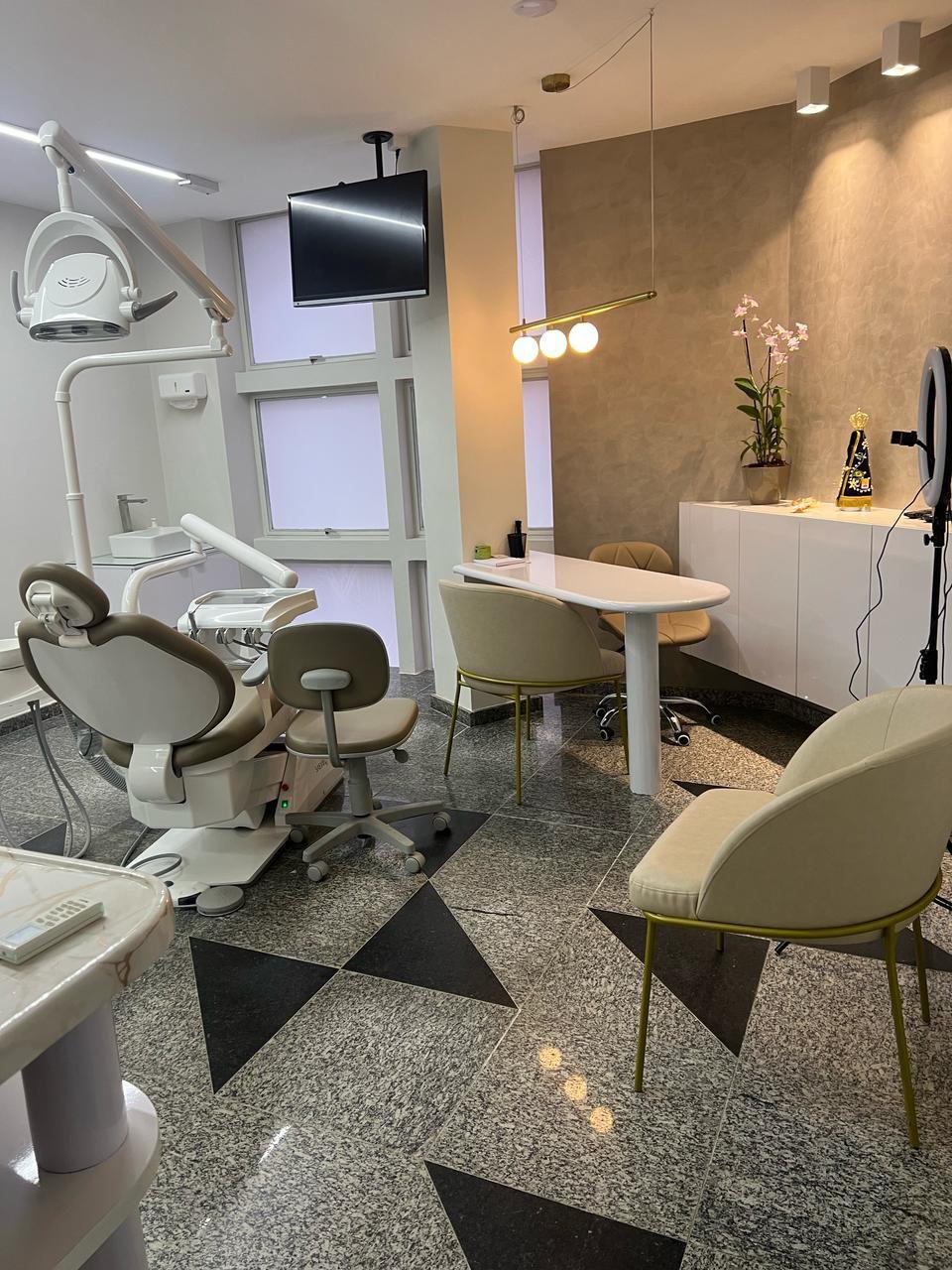 Sala de atendimento com cadeira odontológica e iluminação acolhedora